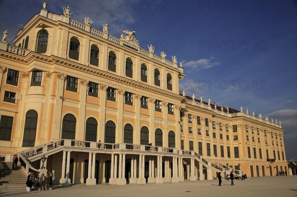 Schonnbrunn Palace. Part view of exterior facade with tourist visitors on flight of steps and in courtyard in foreground. Photo : Bennett Dean