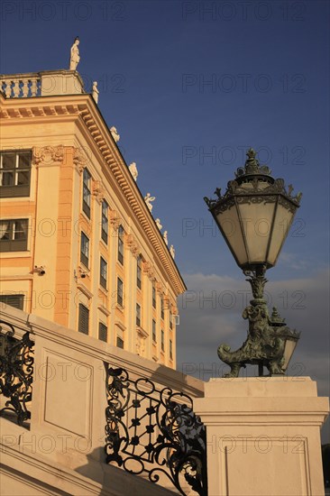 Schonnbrunn Palace. Part view of exterior facade with decorative metal lantern on balcony in foreground. Photo: Bennett Dean