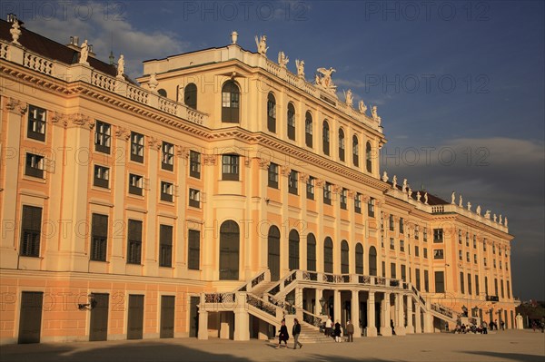 Schonnbrunn Palace. Part view of exterior facade with tourist visitors in courtyard in foreground. Photo : Bennett Dean