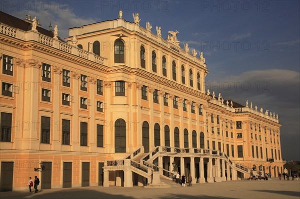 Schonnbrunn Palace. Part view of exterior facade with tourist visitors in courtyard in foreground. Photo: Bennett Dean