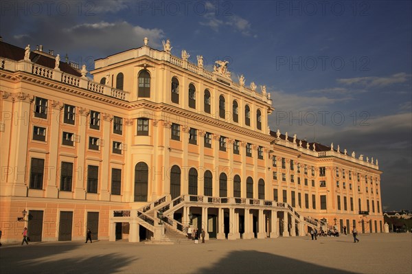 Schonnbrunn Palace. Part view of exterior facade with tourist visitors in courtyard in foreground. Photo : Bennett Dean