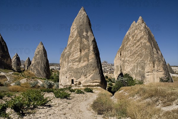 Sword Valley rock formations. The valley got its name because of the appearance of sharp pinnacles of the rock cones found there. The hilltop town of Uchisar in the distance behind. Photo : Hugh Rooney