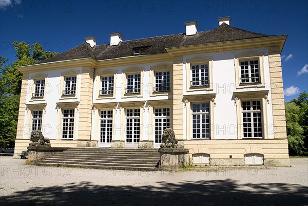 Nymphenburg Palace Badenburg or Bathing House inspired by the luxury of Turkish Baths. Yellow and white painted exterior facade with stone steps flanked by lion statues leading to entrance. Photo: Hugh Rooney