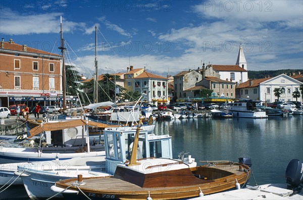 Port with fishing boats. People walking past shops and restaurants. Photo : Jonas Grau