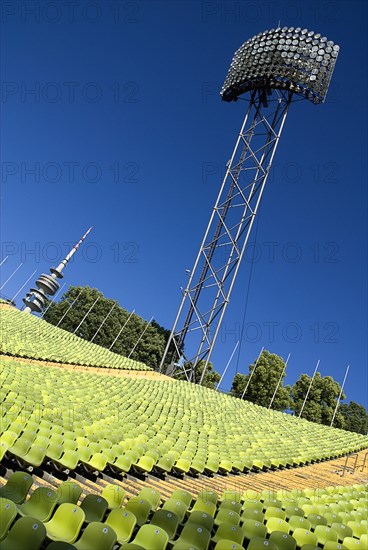 Olympic Stadium. Angled view across green seating of the stadium with floodlight and part view of the Olympic Tower behind. Photo : Hugh Rooney