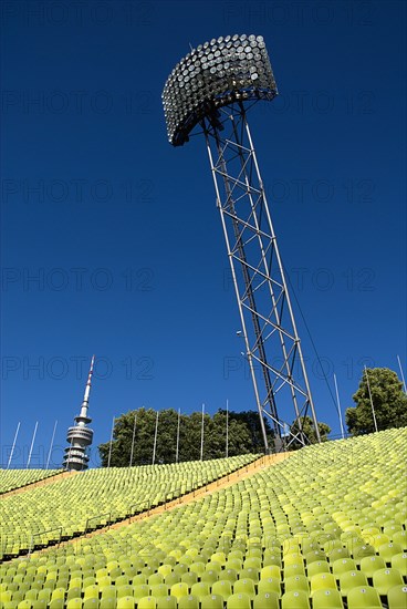 Olympic Stadium. Angled view across green seating of the stadium with floodlight and part view of the Olympic Tower behind. Photo : Hugh Rooney