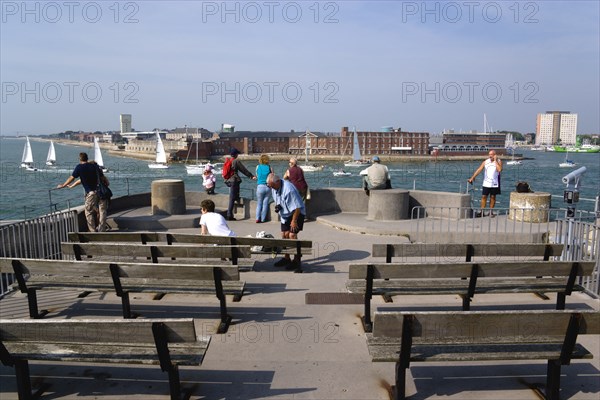 Tourists and seats on the top of The Round Tower in Old Portsmouth and yachts passing through the entrance to the harbour with HMS Dolphin in Gosport on the far side. Photo : Paul Seheult