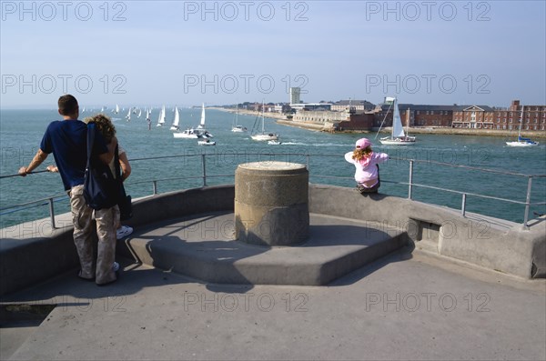 Tourists on the top of The Round Tower in Old Portsmouth and yachts passing through the entrance to the harbour with HMS Dolphin in Gosport on the far side. Photo: Paul Seheult