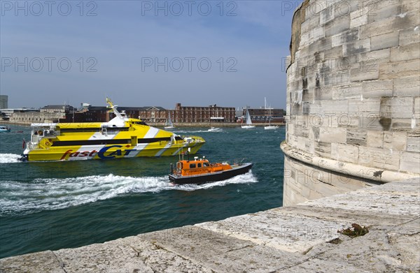 A Pilot boat and catamaran ferry entering the harbour between HMS Dolphin in Gosport and The Round Tower in Old Portsmouth. Photo: Paul Seheult