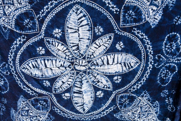 Colourful blue and white tie dyed tablecloth displayed in market. Photo : Mel Longhurst