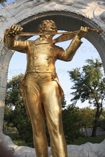 Part view of statue of Johann Strauss in the Stadt Park framed by stone arch. Photo: Bennett Dean