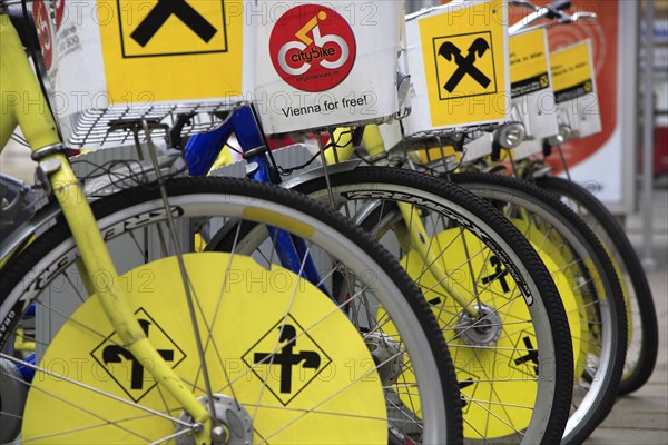 Cropped view of wheels of line of bicycles for public hire. Photo : Bennett Dean