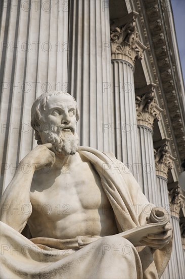 Statue of the Greek philosopher Herodotus in front of columns of the Parliament Building. Photo : Bennett Dean