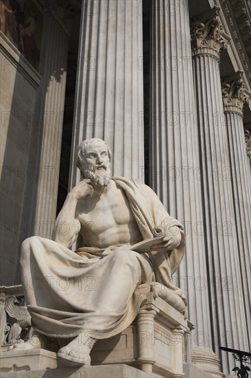 Statue of the Greek philosopher Herodotus in front of columns of the Parliament Building. Photo : Bennett Dean