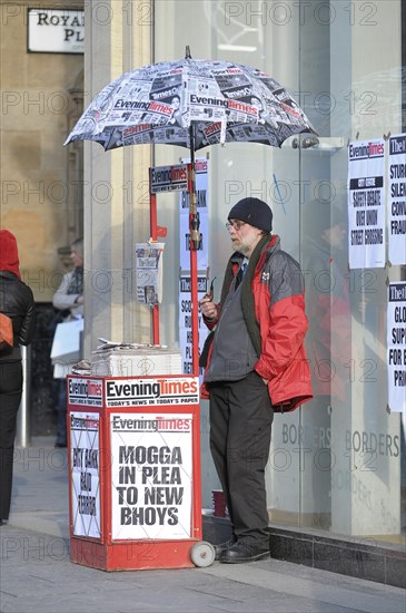 Pipe smoking Evening Times newspaper street vendor. Photo : Steve Lindridge