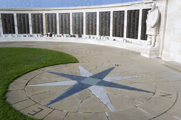 World War Two Naval memorial on Southsea seafront designed by Sir Edmund Maufe with sculpture by William McMillan of a Royal Marine Commando with the Roll Of Honour of the fallen beyond and a compass plaque on the paving stones in the foreground. Photo : Paul Seheult