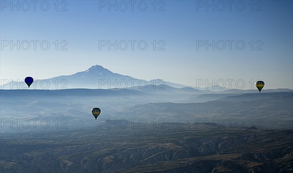 Early morning with hot air balloons in flight mist drifting across landscape and Mount Erciyes in the background. Photo: Hugh Rooney