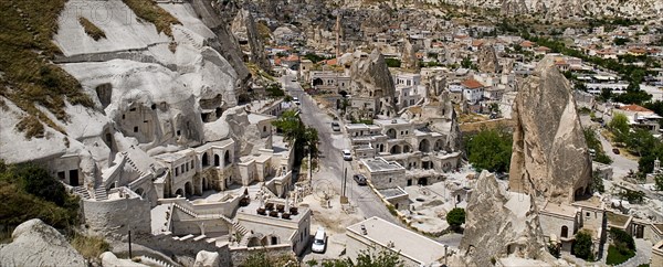 Cave hotel built into white tufa rock of hillside with part view of the town beyond. Photo: Hugh Rooney