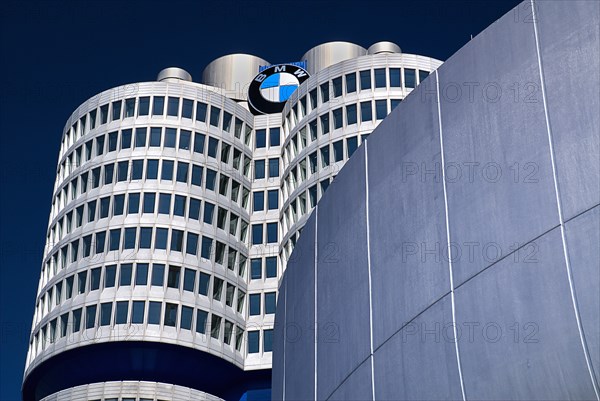 BMW Headquarters exterior. BMW Tower which stands 101 metres tall and mimics the shape of tyres part view seen behind curved wall of building in foreground. Photo : Hugh Rooney