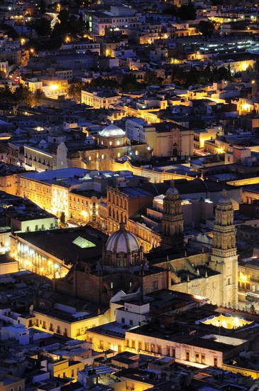 Mexico, Bajio, Zacatecas, View over the city rooftops illuminated at night from Cerro de la Buffa. 
Photo : Nick Bonetti