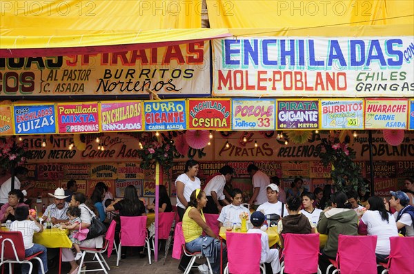 Mexico, Bajio, Zacatecas, Feria food stalls with customers eating on tables outside. 
Photo : Nick Bonetti
