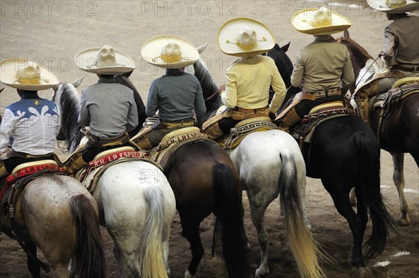 Mexico, Bajio, Zacatecas, Traditional horsemen or Charros standing mounted in line watching the competition at Mexican rodeo. 
Photo : Nick Bonetti