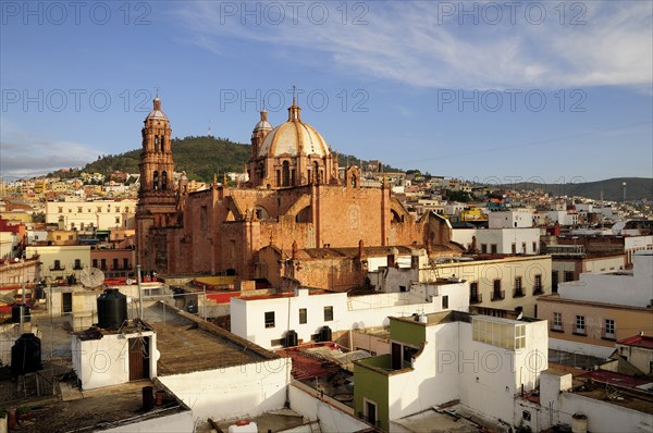 Mexico, Bajio, Zacatecas, View across flat rooftops of houses towards Cathedral. 
Photo : Nick Bonetti