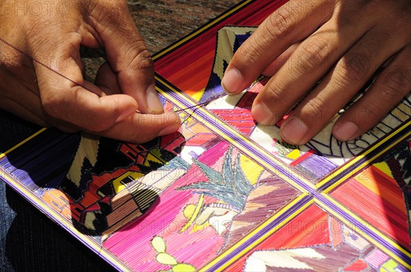 Mexico, Puebla, Cholula, Cropped view of artist making reed painting. 
Photo : Nick Bonetti