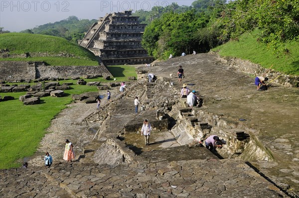 Mexico, Veracruz, Papantla, El Tajin archaeological site Archaeologists at work at Tajin Chico with Pyramide de lo Nichos beyond. 
Photo : Nick Bonetti