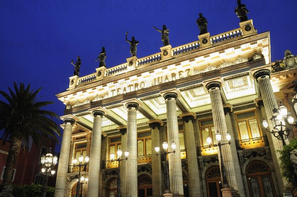 Mexico, Bajio, Guanajuato, lluminated exterior facade of Theatre Juarez with line of rooftop statues at night. 
Photo : Nick Bonetti