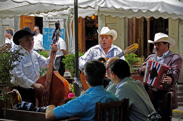 Mexico, Bajio, Guanajuato, Mariachi musicians playing at cafe in Jardin de la Union. 
Photo : Nick Bonetti