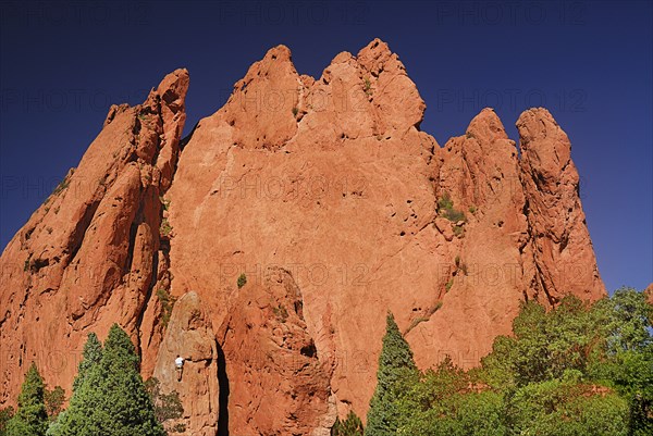 USA, Colorado, Colorado Springs, Garden of the Gods public park figure of climber on face of large rock formation with multiple peaks. 
Photo : Hugh Rooney