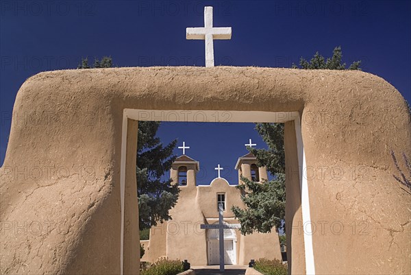 USA, New Mexico, Taos, Church of San Francisco de Asis. Entrance framing view to church exterior and white painted crosses. 
Photo : Hugh Rooney