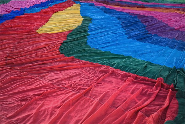 USA, New Mexico, Albuquerque, Annual balloon fiesta. Detail of colourful hot air balloon spread over ground before inflating. 
Photo : Hugh Rooney