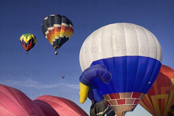 USA, New Mexico, Albuquerque, Annual balloon fiesta colourful hot air balloons ascending. 
Photo : Hugh Rooney