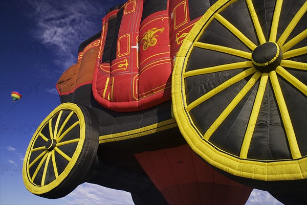 USA, New Mexico, Albuquerque, Annual balloon fiesta colourful hot air balloons. Part view of balloon shaped in the form of a royal coach in foreground. 
Photo : Hugh Rooney