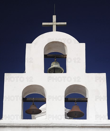 USA, Arizona, Tucson, Mission Church of San Xavier del Bac. White painted bell tower with three bells and topped with a cross. 
Photo : Hugh Rooney