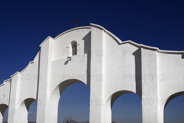 USA, Arizona, Tucson, Mission Church of San Xavier del Bac. Exterior detail of white painted archway with sculpture set in central niche. 
Photo : Hugh Rooney
