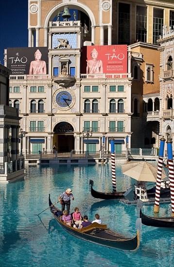 USA, Nevada, Las Vegas, The Strip tourists in gondola outside the entrance to the Venetian hotel and casino. 
Photo : Hugh Rooney