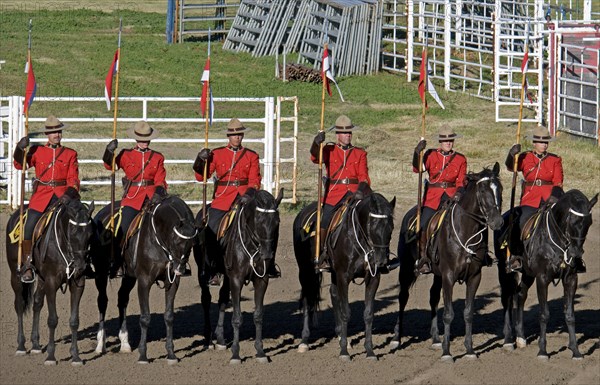 Canada, Alberta, Lethbridge, Royal Canadian Mounted Police Musical Ride RCMP cavalry in full dress red serge uniform on horseback holding lances with red and white pennons. 
Photo : Trevor Page