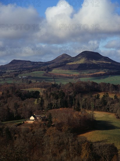 Scotland, Borders, Melrose, Eildon Hills circa 422 metres from Scotts View. Rooftops of house in foreground and agricultural land bordered by trees. 
Photo : Bryan Pickering