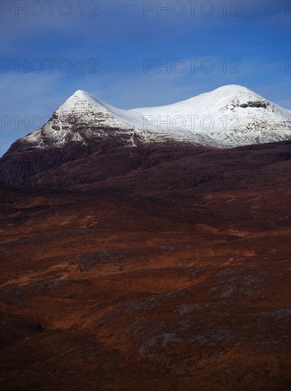 Scotland, Highlands, Coigach, Drumrunie Forest. Twin peaks of Culmor at 849 metres with the upper reaches covered in snow. View from Knockan Crag. 
Photo : Bryan Pickering