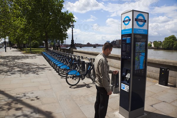 England, London, Vauxhall Albert Embankment of the river Thames man buying time on bicycle hire self service machine. 
Photo : Stephen Rafferty