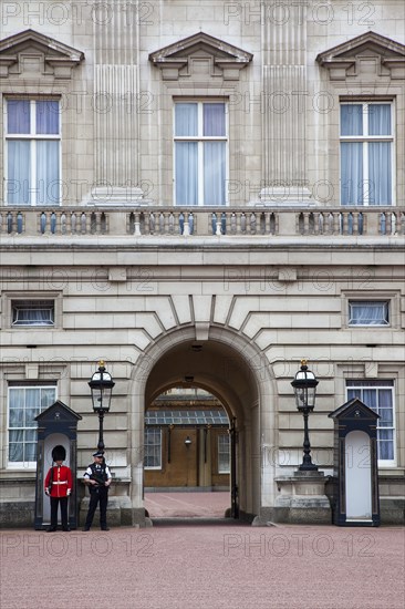 England, London, Westminster Buckingham Palace exterior with both Queens Guard and Metropolitan Police armed officers. 
Photo : Stephen Rafferty