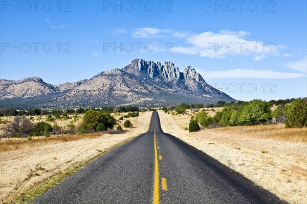 USA, Texas, Fort Davis, Country road toward mountain. 
Photo : Richard Rickard