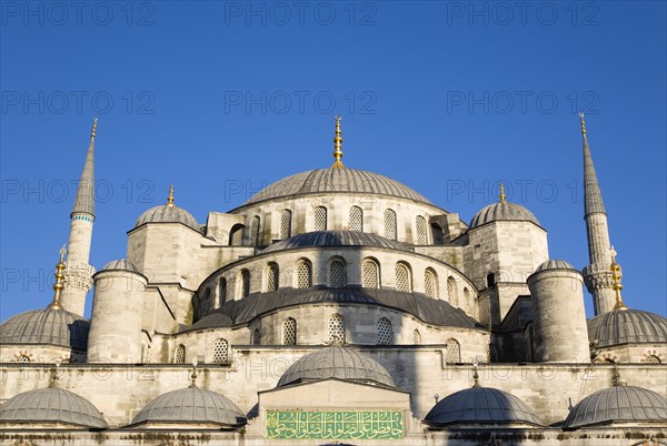 Turkey, Istanbul, Sultanahmet Camii The Blue Mosque domes seen from the Courtyard with Arabic text from the Koran. 
Photo : Paul Seheult