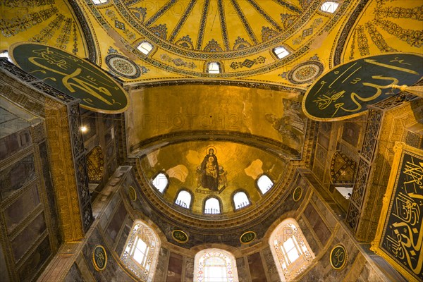 Turkey, Istanbul, Sultanahmet Haghia Sophia with apse mosaic of Theotokos or Virgin Mary enthroned holding the baby Jesus Christ below the dome and Arab Muslim texts on Calligraphic Roundels on the walls. 
Photo : Paul Seheult