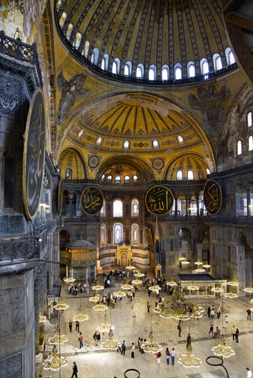 Turkey, Istanbul, Sultanahmet Haghia Sophia The nave with tourists sightseeing below the dome and suspended lights. 
Photo : Paul Seheult