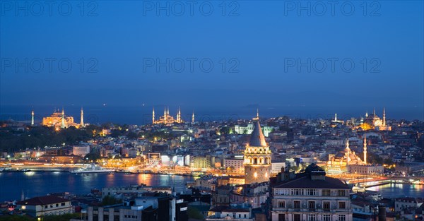 Turkey, Istanbul, View at sunset of illuminated city skyline from Beyoglu across rooftops to Galata Tower and Golden Horn with Galata Bridge leading to Sultanahmet with Haghia Sophia New Mosque and Blue Mosque with Sea of Marmara beyond. 
Photo : Paul Seheult