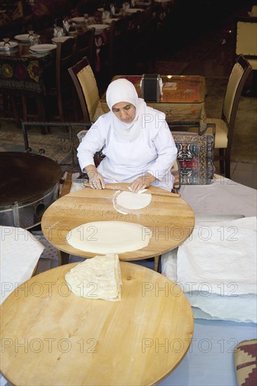 Turkey, Istanbul, Sultanahmet woman rolling out bread dough in restaurant. 
Photo : Stephen Rafferty